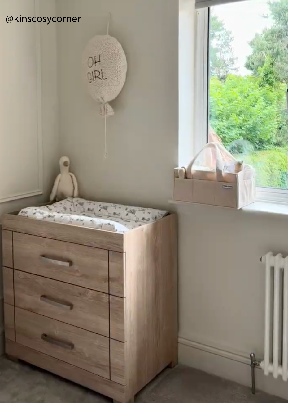 Nursery room with wooden changing table and window view