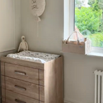 Nursery room with wooden changing table and window view
