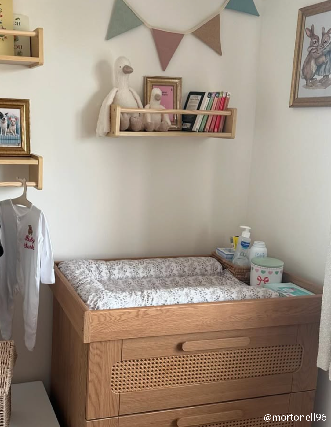 Nursery room with wooden changing table, shelves, and decorative elements.